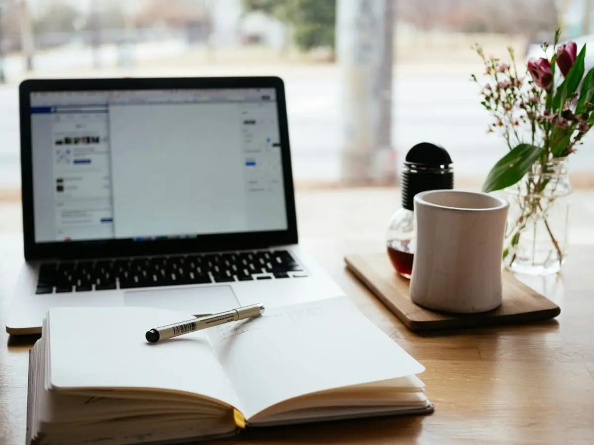 Laptop and an open book on a desk